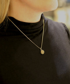 ROS 18K halsband med ett litet rosformigt hänge på en slank kedja.