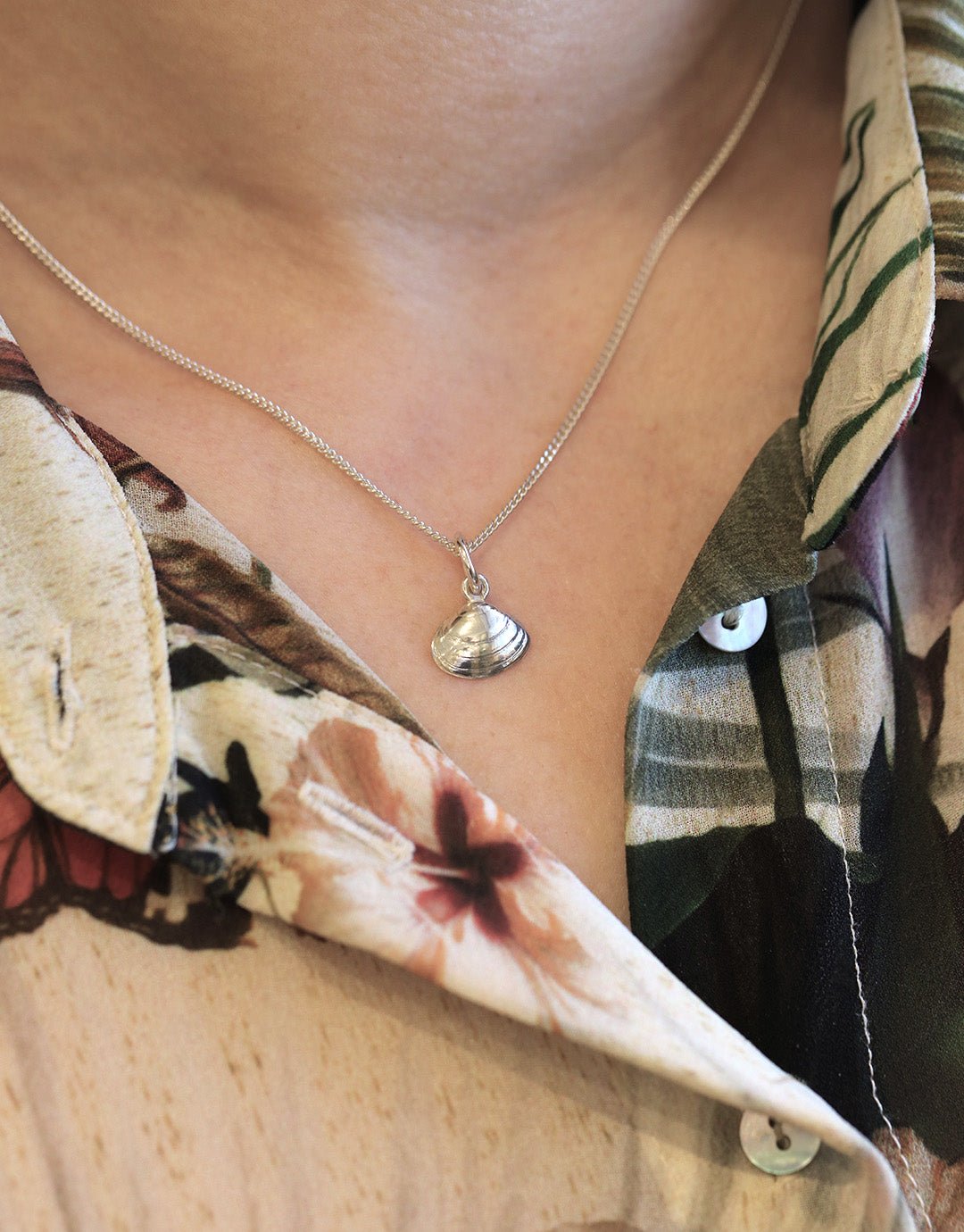 Närbild på SANDMUSSLA XS halsband med musslaformad hänge i sterlingsilver runt halsen