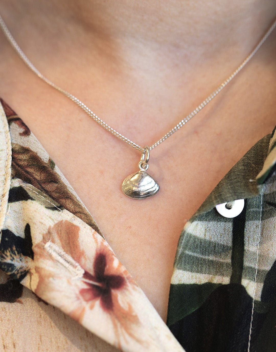 SANDMUSSLA XS halsband med musslaformad hänge i sterlingsilver visas upp nära halsen