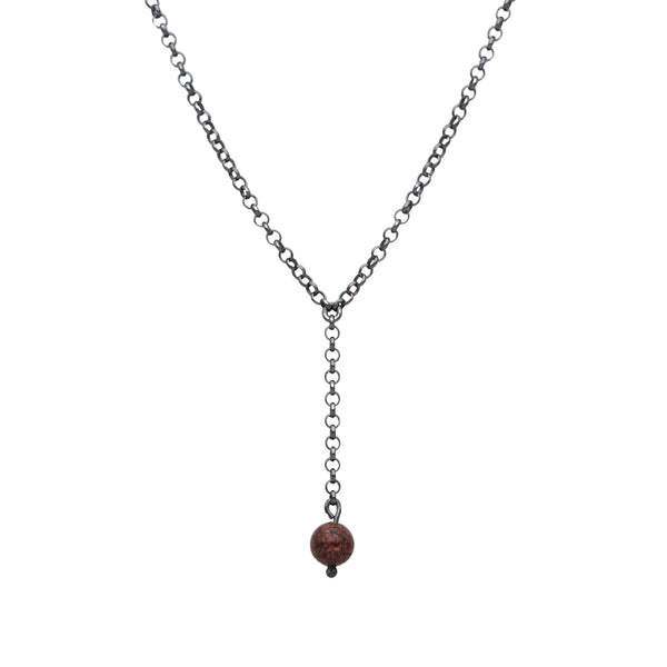 STRAND GRANIT halsband på tråd med två kedjor som möts och en röd rund sten som hänger ned.