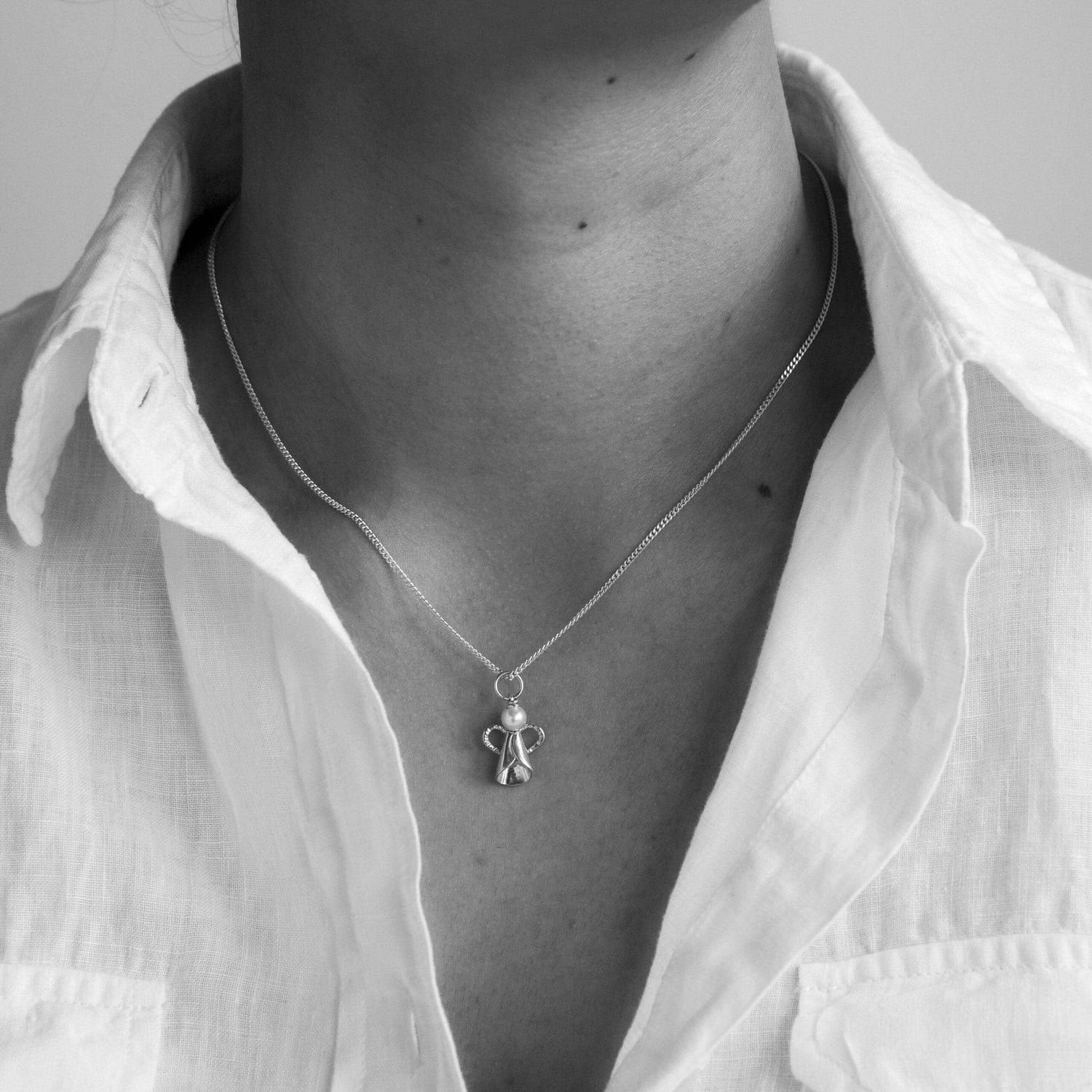 Person bär ÄNGEL halsband med sötvattenpärla i 925 sterling silver runt halsen