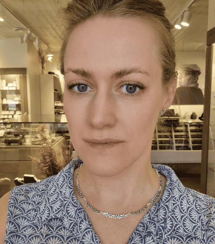 Model wearing the FÖRGÄT MIG EJ collier with flower blossom silver necklace.