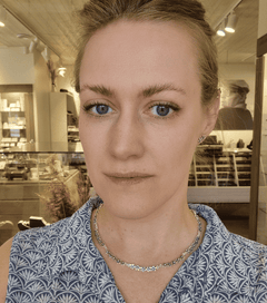 Model wearing the FÖRGÄT MIG EJ collier with flower blossom silver necklace.