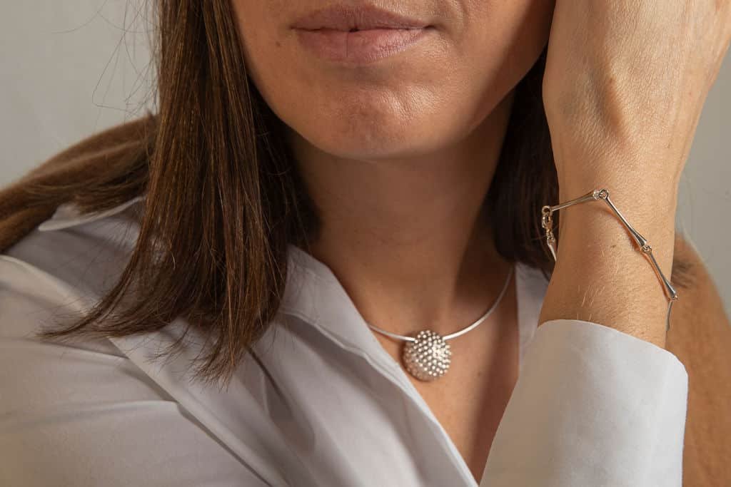 Peggy armband in sterling silver worn on a woman's wrist with peg inspired geometric links