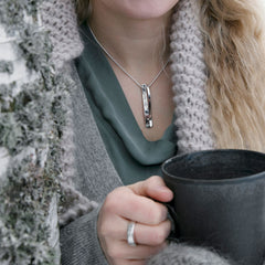 Model bär STAM halsband i sterlingsilver med två parallella stavar som hänger ned