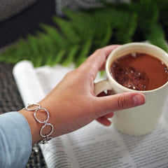 CIRCLA armband i sterlingsilver med upprepade cirkelformade länkar som glittrar på handleden