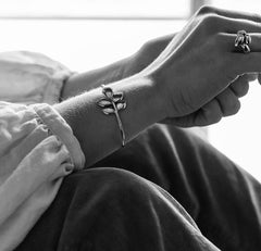 Närbild av bladformad armring runt handleden i sterlingsilver