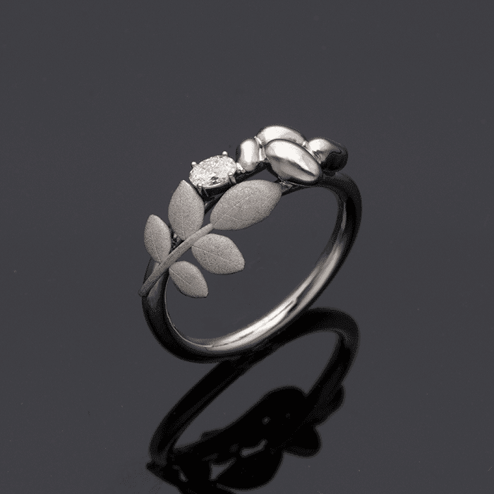 EVA 18K ring featuring a central diamond and leaf accents along the band