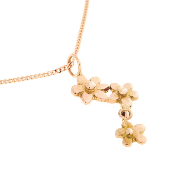 Roséfärgat halsband med förgät mig ej blommor längs kedjan och en nedhängande blomma
