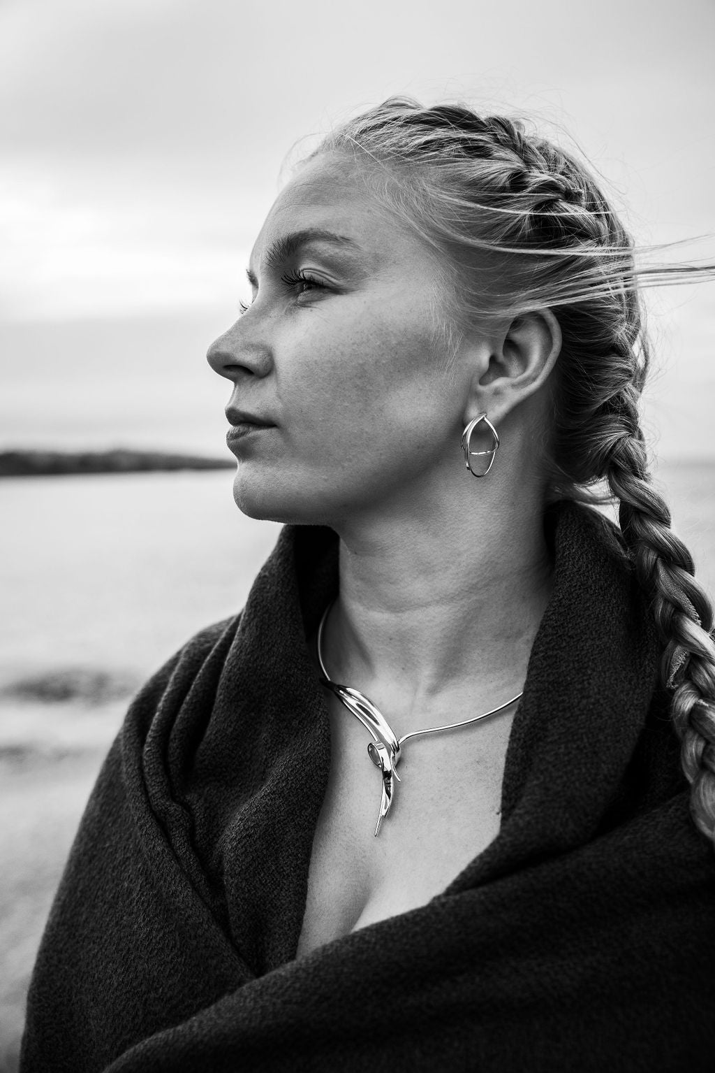 Profile view of a woman wearing STORMSKÄRS MAJA FEST Collier with matching silver hoop earrings