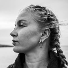 Profile view of a woman wearing STORMSKÄRS MAJA FEST sterling silver stud earrings