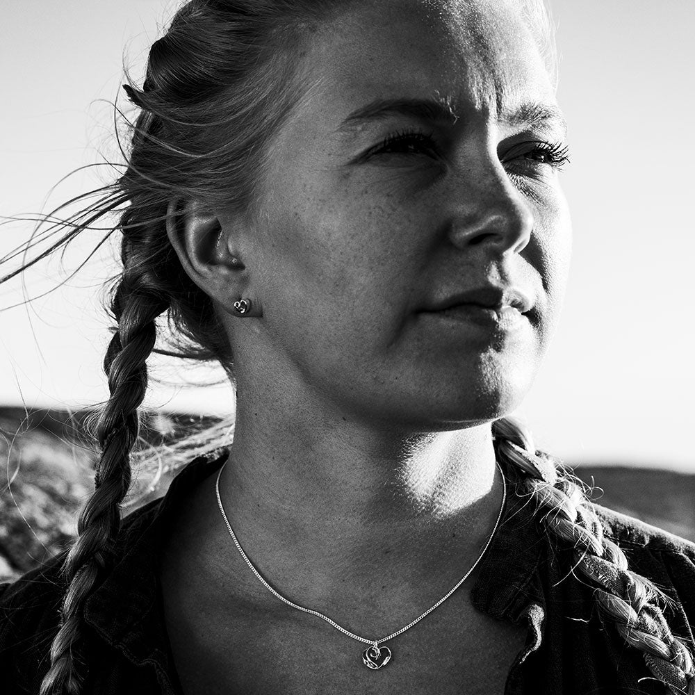 Black and white portrait of a woman with braided hair wearing a sterling silver heart pendant necklace