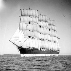 Black and white photograph of a tall sailing ship with full sails evoking Åland maritime heritage behind the collier