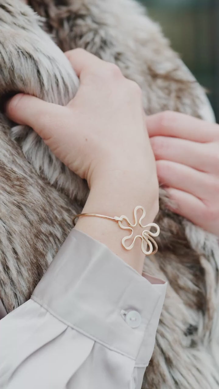 Närbild av Blomman-armbandet på handleden.