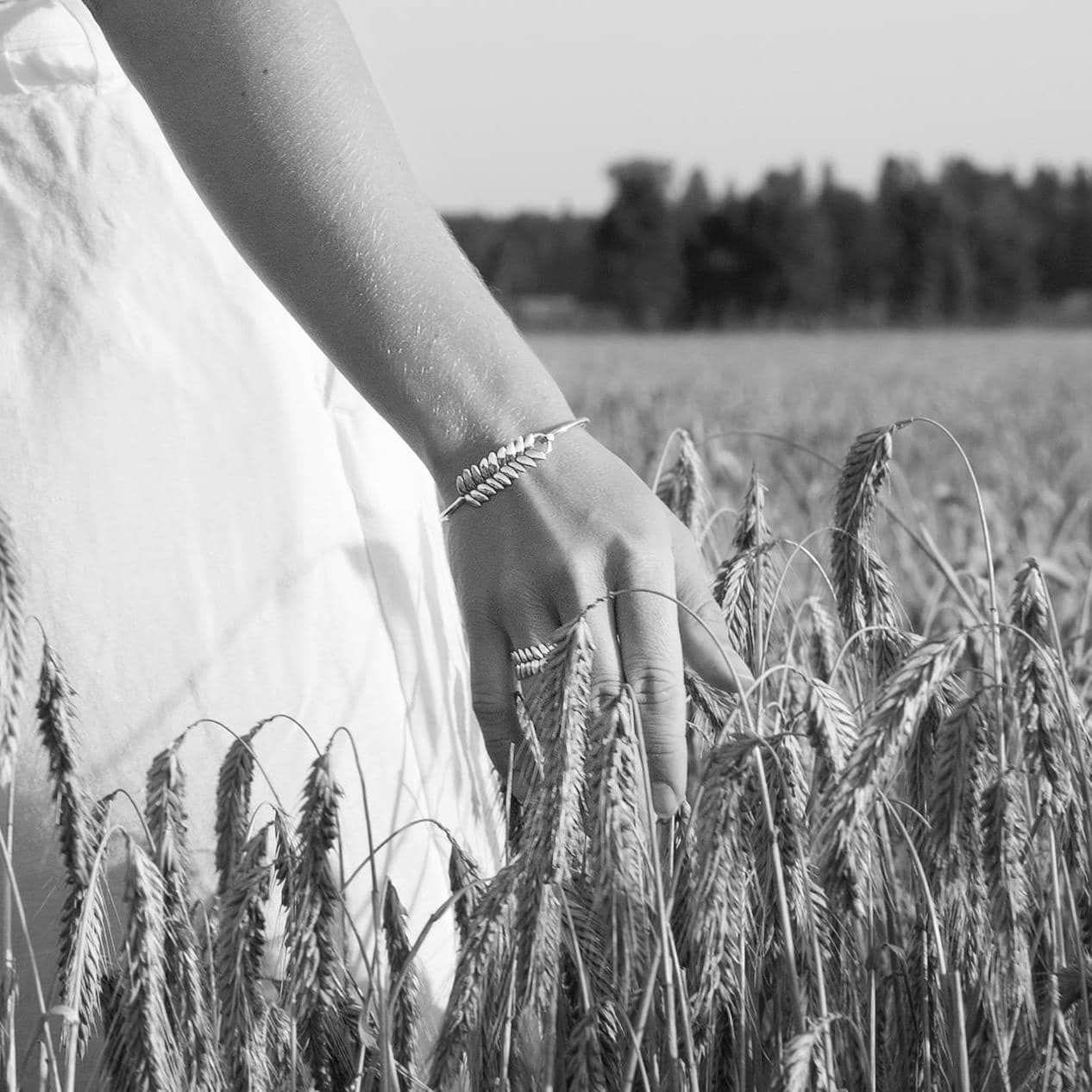 Närbild på handleden med RÅG armband i sterlingsilver i ett fält