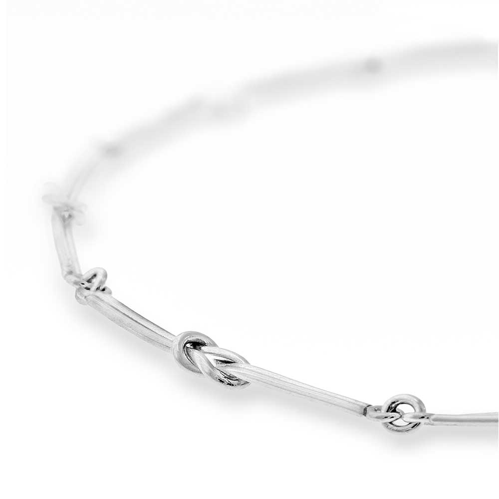 Close-up of RÅBANDSKNOP collier showing knotted silver links and ring connectors