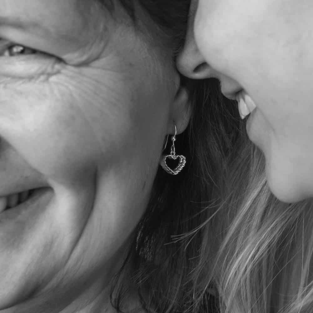 Närbild av RÅGHJÄRTA örhänge i silver som hänger från krok med en hjärtformad ring