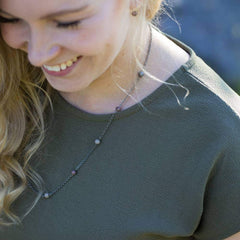 STRAND halsband 60 cm i silverkedja med färgade stenar på en kvinna i grön topp