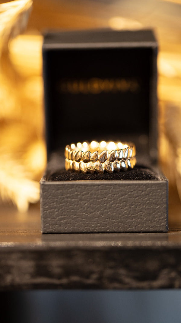 RÅG ROBUST 18K gold ring with a textured leaflike band displayed in a black box