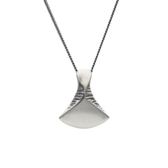 Solid silver axe pendant on a dark antique chain against a white background